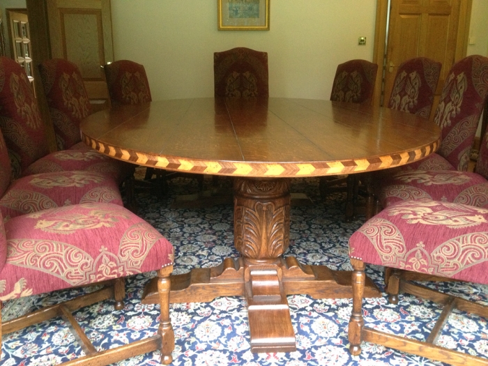 Oval Oak Dining Table with Inlay and Carved Cup and Cover Legs and a set of Upholstered Chairs