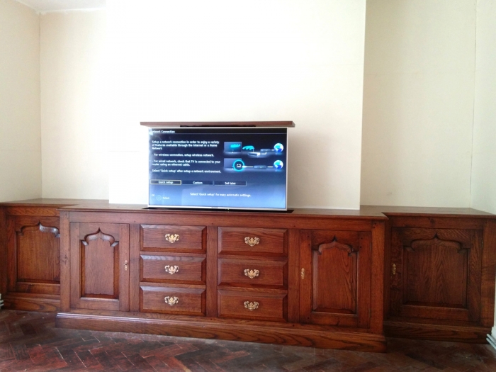 Fitted Oak TV and Media Cabinet, the TV rises and lowers with a remote controlled lift system. The drawer fronts are false and lift out to give access to the power unit and wiring. The left centre door opens and slides back into the unit to leave set top boxes etc unobstructed whilst in use.