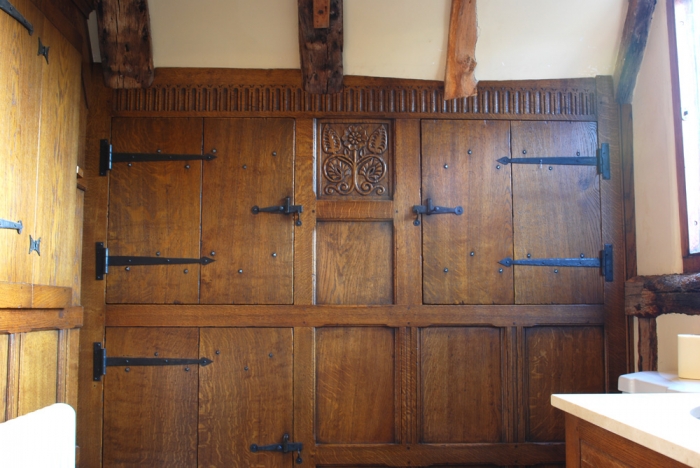 Fitted Oak Cupboard with Hand Carving and Forged Ironmongery the Carved Rail has been expertly Scribed to fit around the Beams and Ceiling shape