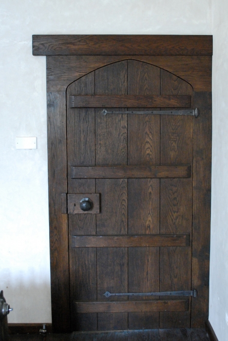 A Shaped Boarded and Ledged Oak Door with Frame and Bespoke Ironmongery